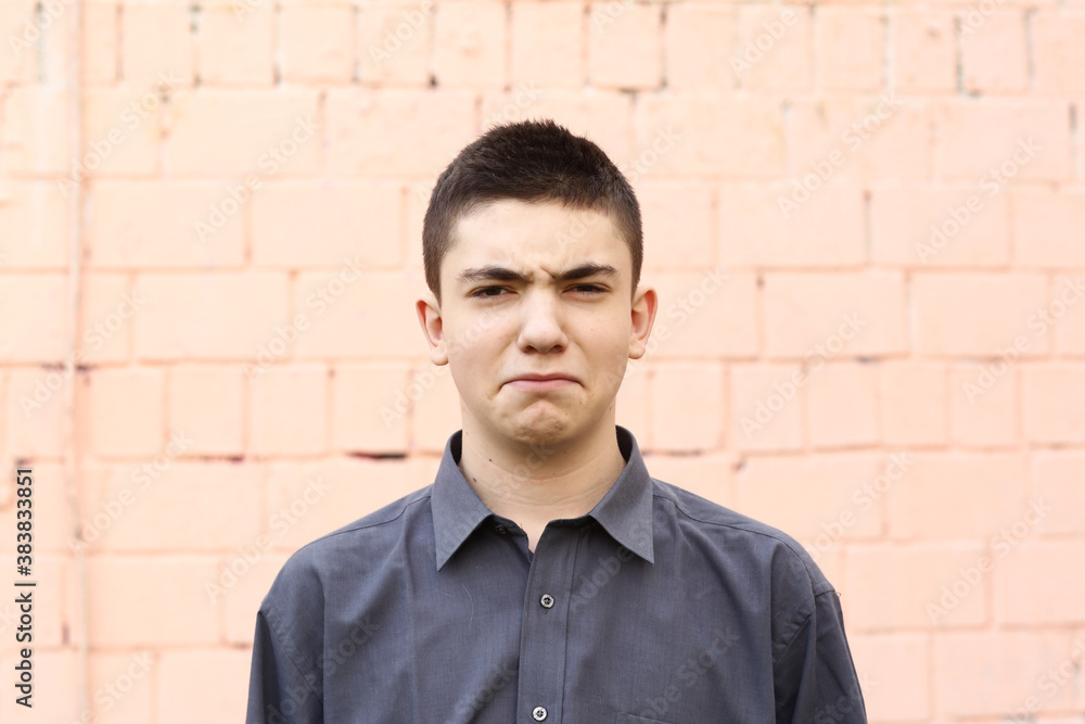 happy teenager boy grimace wink closeup portrait on white wall background happy teenager boy grimace wink closeup portrait on white wall background