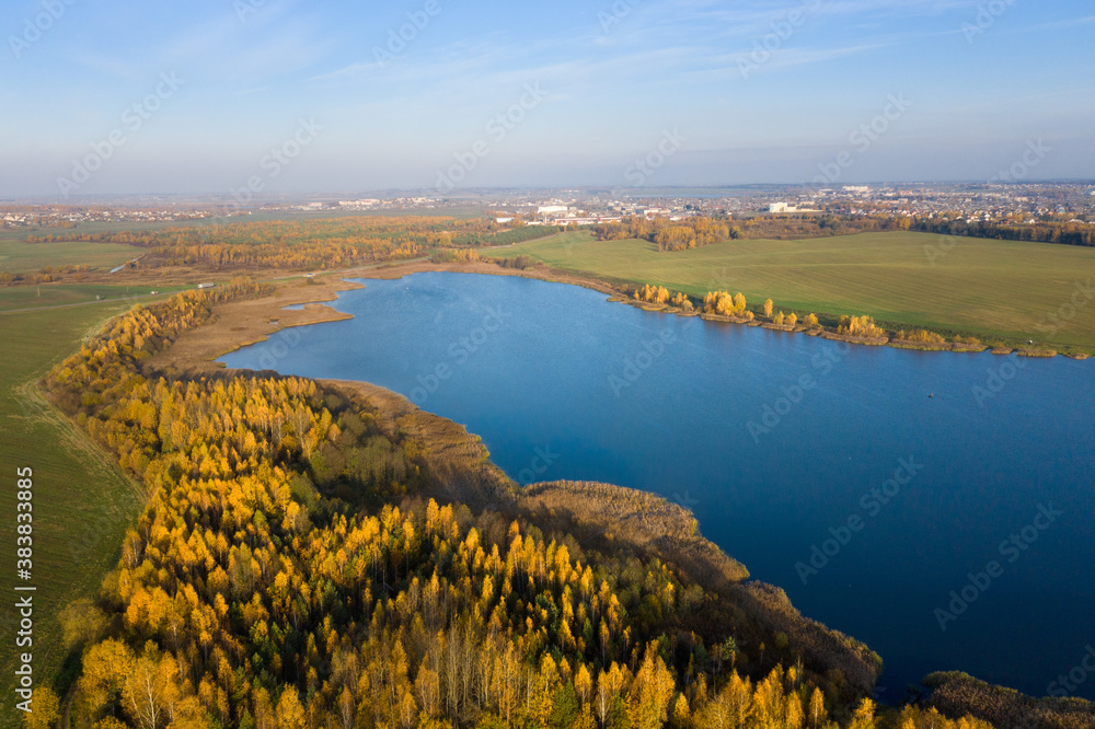 Autumn panorama. Aerial view on woods, lake and town. Sunny autumn day above woods and lake. Beautiful  october.
