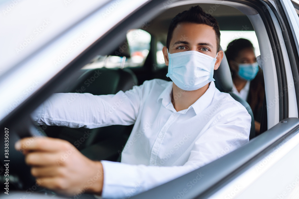 Man driving a car in protective sterile medical mask during an epidemic in quarantine city. Covid- 19. Man driving a car in protective sterile medical mask during an epidemic in quarantine city. Covid- 19.