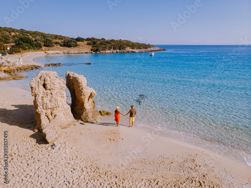 Tropical beach of Voulisma beach, Istron, Crete, Greece ,Most beautiful beaches of Crete island -Istron bay near Agios Nikolaos drone aerial view, couple walking on the ebach photo