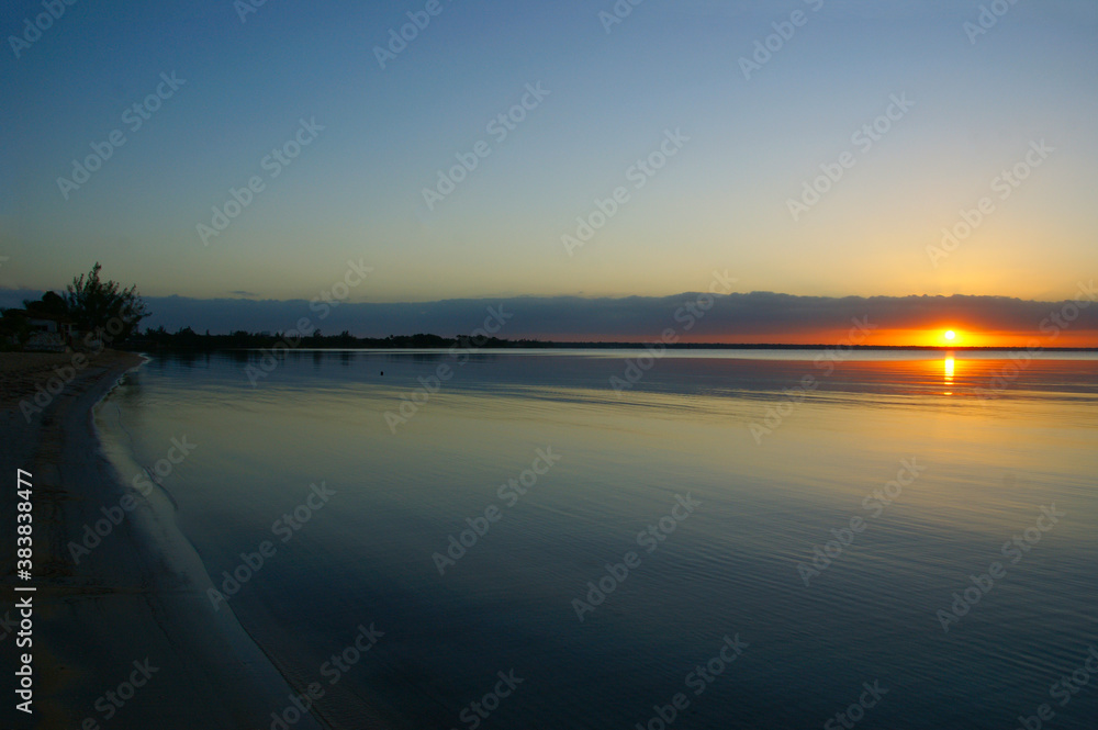 dawn on a tropical island. dawn in the tropics. calm water in which the rising sun is reflected