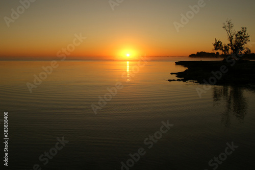 dawn on a tropical island. dawn in the tropics. calm water in which the rising sun is reflected © Otar