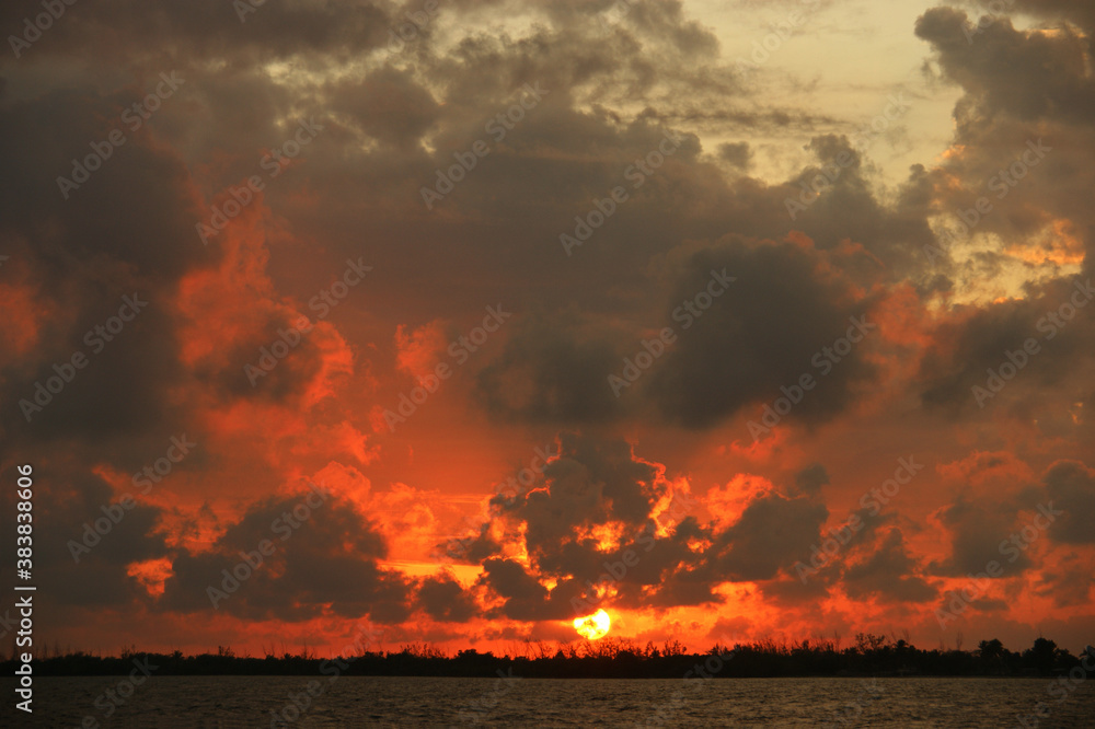 Dramatic sky at sunset with red, yellow and orange colors. The reflection of dramatic clouds in the sea enhances the effect Dramatic sky at sunset with red, yellow and orange colors. The reflection of dramatic clouds in the sea enhances the effect