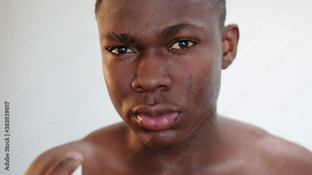 Man skincare. Male grooming. African guy spaying antiseptic aftershave ...