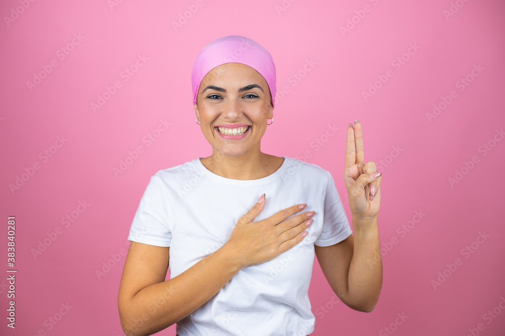 Young beautiful woman wearing pink headscarf over isolated pink background smiling swearing with hand on chest and fingers up, making a loyalty promise oath Young beautiful woman wearing pink headscarf over isolated pink background smiling swearing with hand on chest and fingers up, making a loyalty promise oath