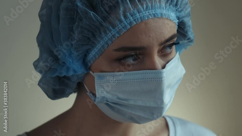 Tired medical worker in mask. Woman doctor in surgical mask close up, girl nurse looks sad. Coronavirus Covid-19 pandemic concept