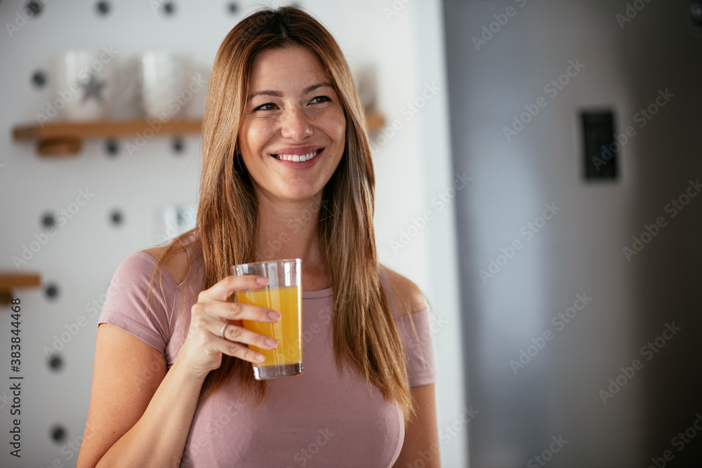 Young woman in kitchen. Beautiful woman preparing breakfast and drinking juice. Young woman in kitchen. Beautiful woman preparing breakfast and drinking juice.