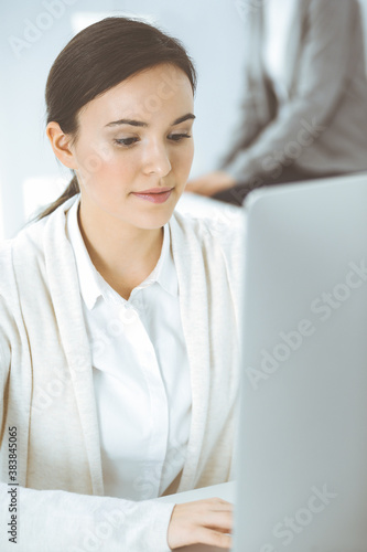 Casual dressed business woman working with computer in office. Lawyer or accountant at work