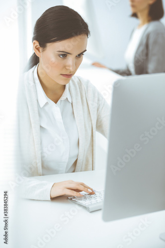 Casual dressed business woman working with computer in office. Lawyer or accountant at work