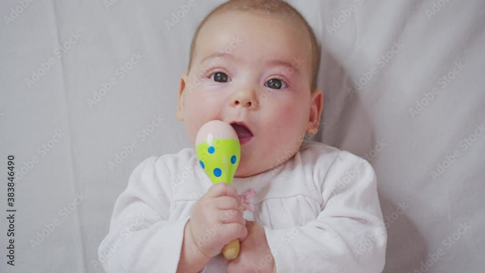 Adorable little baby playing a toy on bed. Adorable little baby playing a toy on bed.