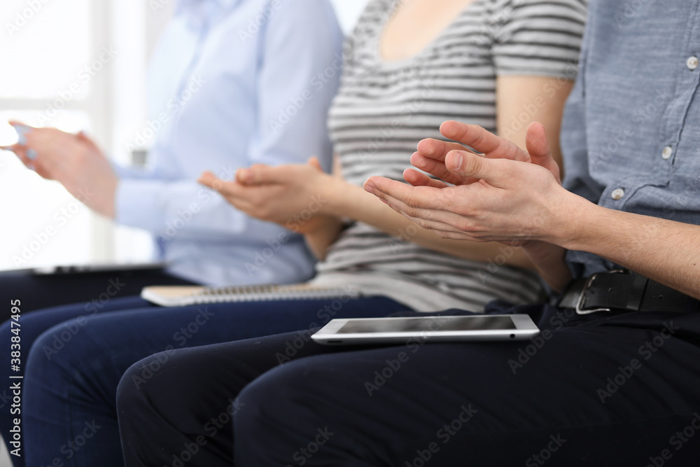 Business people clapping at meeting or conference, close-up of hands. Group of unknown businessmen and women in modern white office. Success teamwork, corporate coaching and applause concept