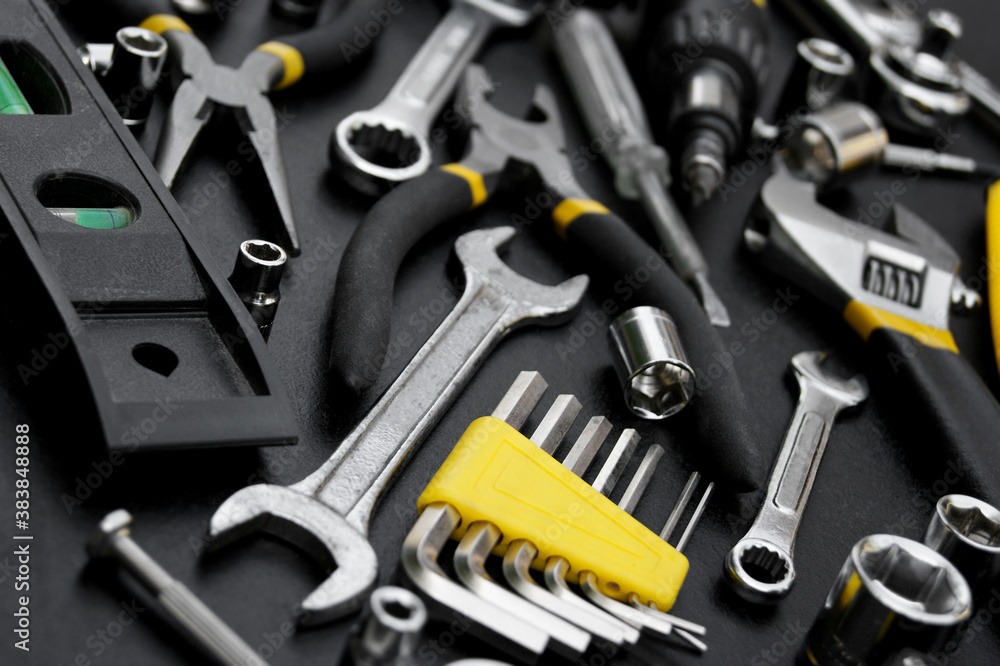 Fototapeta premium Many different tools for repair work on a black background.