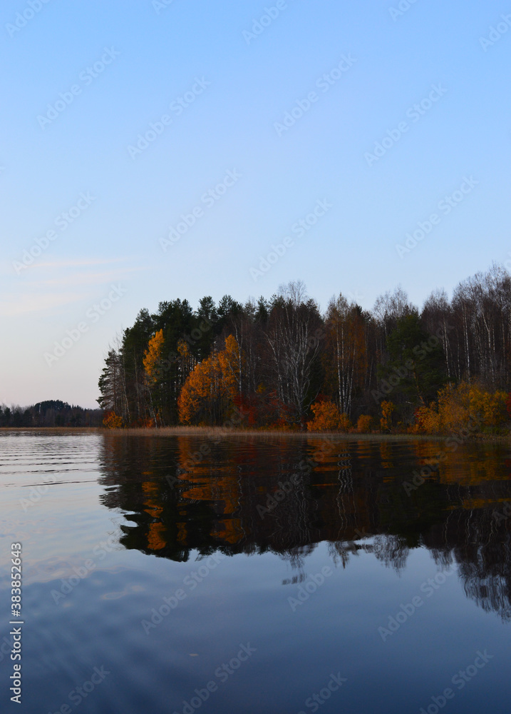 Autumn on the lake. Cool, clear water and little island with autumn colors.