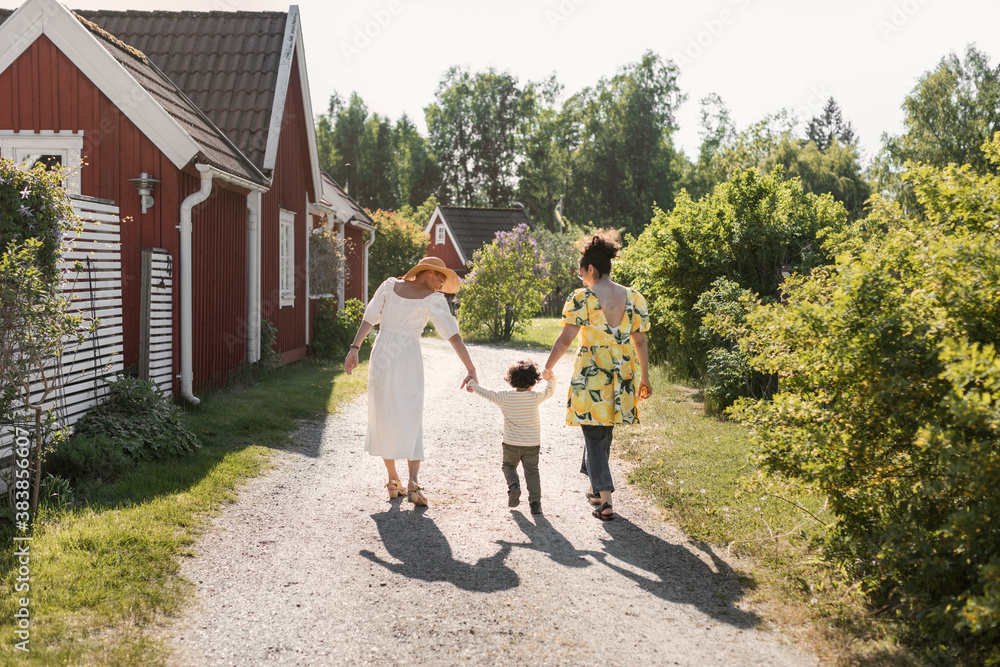 Toddler walking with mother and grandmother