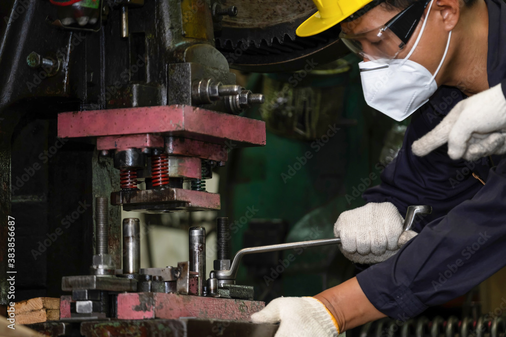 Engineer or worker wearing a helmet, mask and safety glasses using