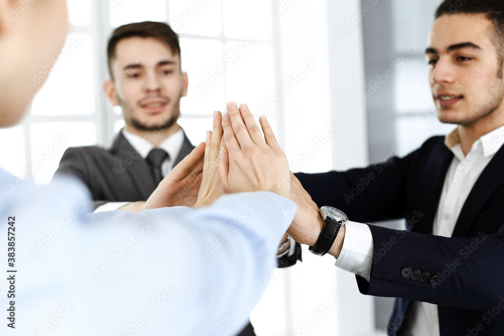 Business people group showing teamwork, joining hands and giving five to each other in modern office. Success concept Business people group showing teamwork, joining hands and giving five to each other in modern office. Success concept
