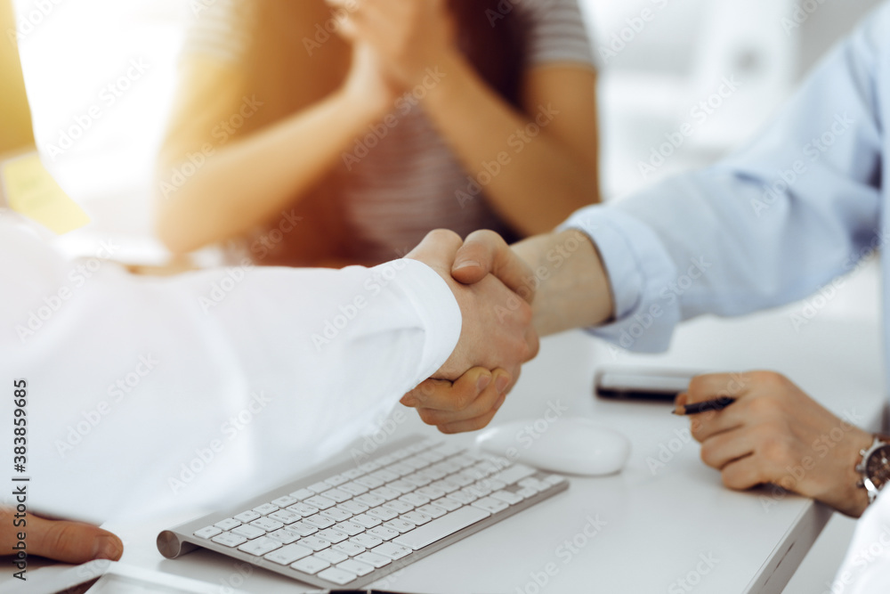 Two businessmen shaking hands in sunny office, close-up. Colleagues applauding of success meeting end Two businessmen shaking hands in sunny office, close-up. Colleagues applauding of success meeting end