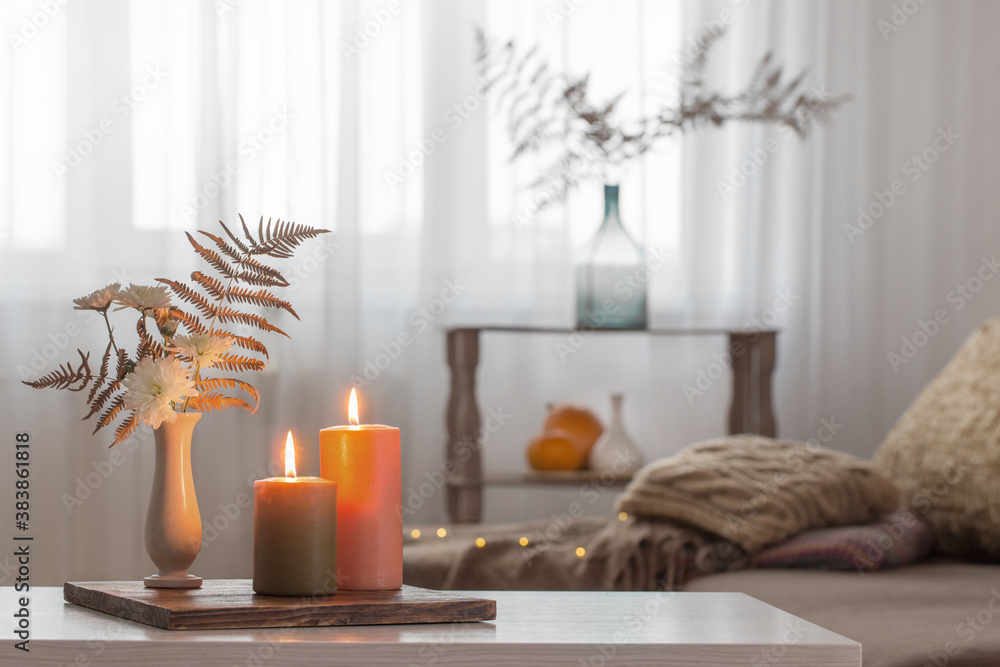 burning candles with autumn decor on white table at home - obrazy, fototapety, plakaty 