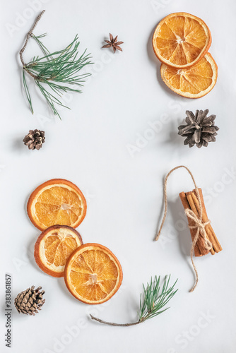 Dried orange, anise, pine cone, cinnamon and pine branches on a white background