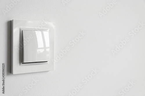 A white plastic power switch in an apartment on a white wall