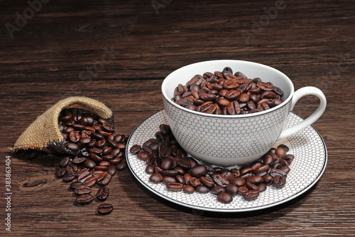 Topped with coffee cup and coffee beans on wooden background