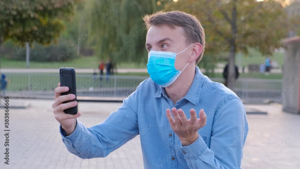 Young man in protective mask communicates online via video call. Living in quarantine during the coronavirus pandemic Young man in protective mask communicates online via video call. Living in quarantine during the coronavirus pandemic