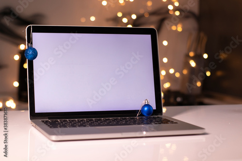 laptop with white screen near New Year's decorations. christmas theme. template. 