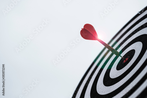 Dart arrow hit dartboard and goal with sunlight ,Setup objectives and target for business investment concept.