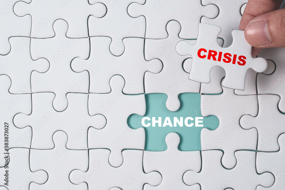 Chance and Crisis concept , Hand pull out white jigsaw which print screen crisis wording to show chance wording on blue background. Chance and Crisis concept , Hand pull out white jigsaw which print screen crisis wording to show chance wording on blue background.