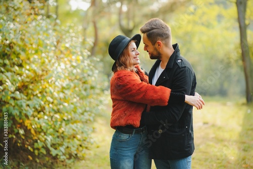 love, relationship, family, season and people concept - smiling couple hugging over autumn natural background © Serhii