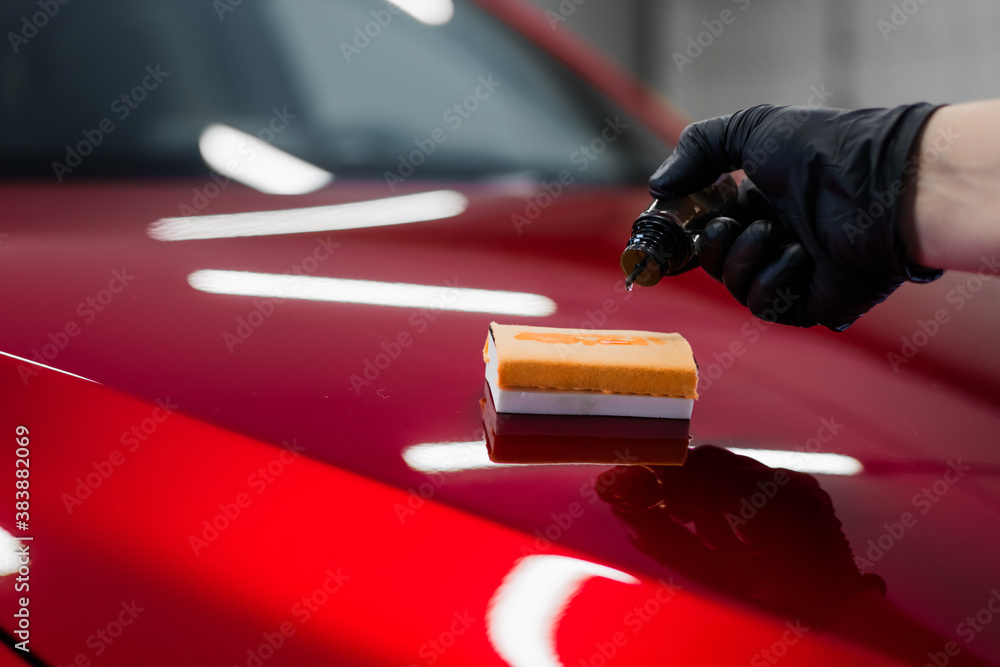 Car detailing - Man applies nano protective coating or wax on red car.  Covering car bonnet with a liquid glass polish. Stock Photo | Adobe Stock