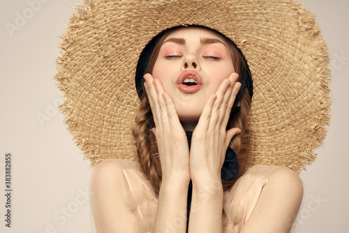 Nice girl in a straw hat with a black ribbon and in a dress on a light background romance model fun emotion