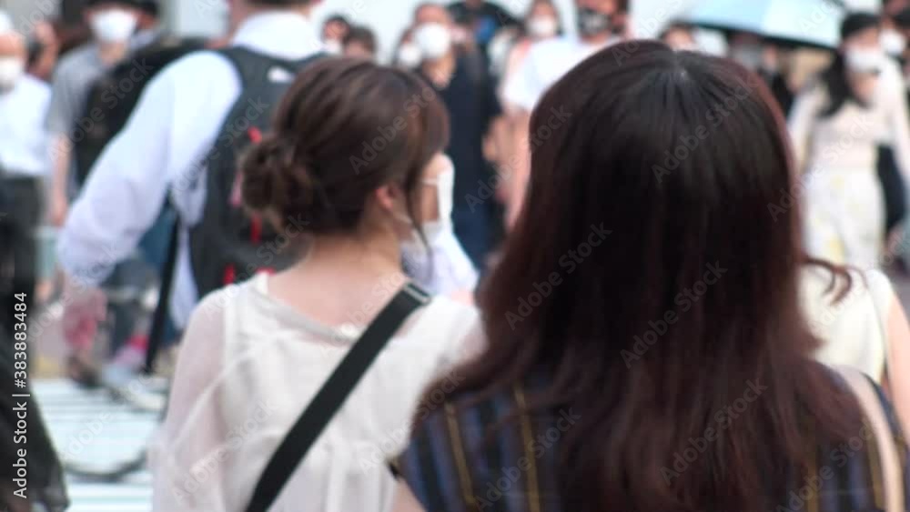 SHIBUYA, TOKYO, JAPAN - AUG 2020 : Back shot and out of focus crowd of people wearing surgical mask to protect from Coronavirus (COVID-19) at Shibuya Crossing. Shot in day time, hot summer season. SHIBUYA, TOKYO, JAPAN - AUG 2020 : Back shot and out of focus crowd of people wearing surgical mask to protect from Coronavirus (COVID-19) at Shibuya Crossing. Shot in day time, hot summer season.