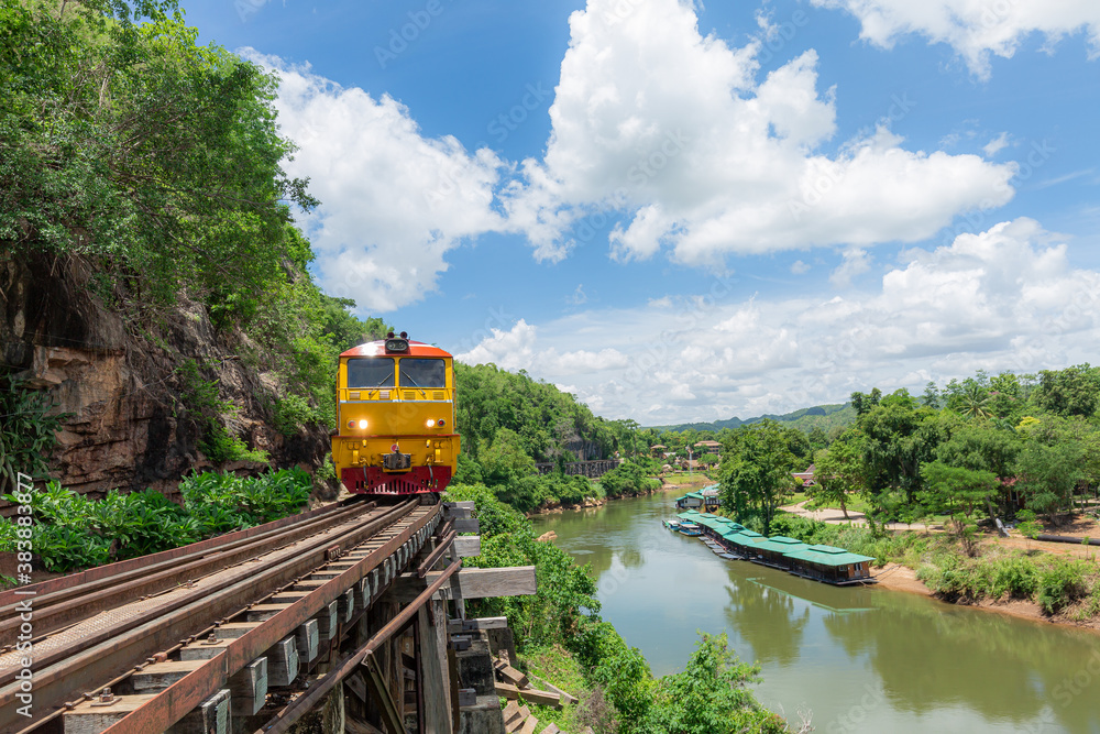 Naklejka premium World war II historic railway, known as the Death Railway with a lot of tourists on the train taking photos of beautiful views over Kwai Noi River.