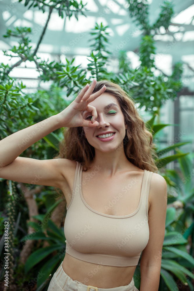 Pretty young woman looking through the fingers and smiling Pretty young woman looking through the fingers and smiling