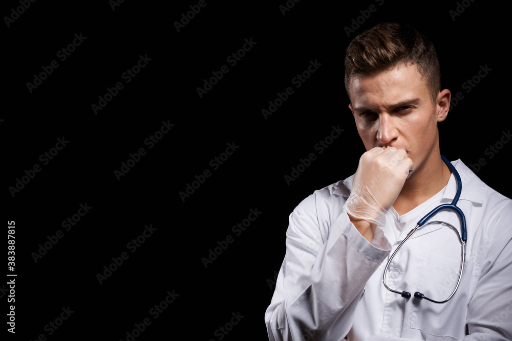 professional doctor in a medical gown with a stethoscope around his neck against a dark background cropped view professional doctor in a medical gown with a stethoscope around his neck against a dark background cropped view