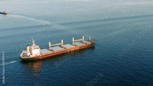 Cargo ship sailing on the ocean to the sea port. A bulk carrier or bulker - a merchant ship specially designed to transport unpackaged bulk cargo, such as grains, ore, coal or timber