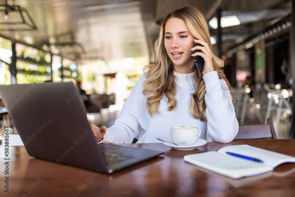 Portrait of pretty woman talking on the phone while sitting in the cafe and enjoying coffee Portrait of pretty woman talking on the phone while sitting in the cafe and enjoying coffee