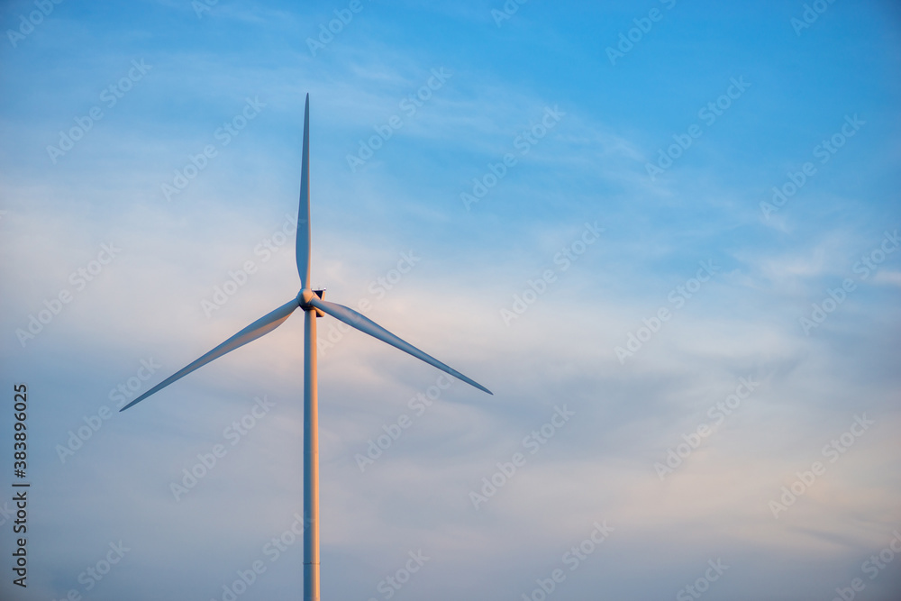 Windmills for electric power production at sunset Windmills for electric power production at sunset