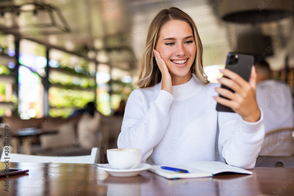 Young woman use phone making video call in cafe Young woman use phone making video call in cafe