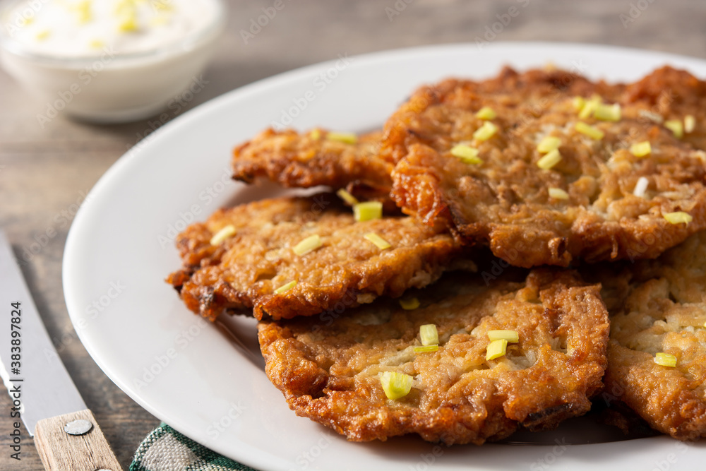 Traditional Jewish latkes or potato pancakes on wooden table Traditional Jewish latkes or potato pancakes on wooden table