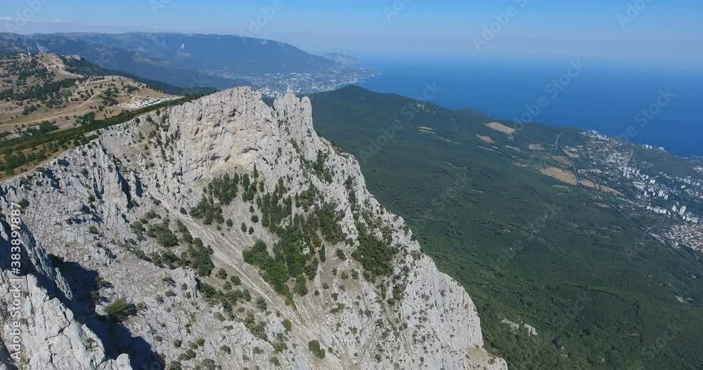 Drone shot flying close to a huge rock cliff. Aerial view on Crimea landscape with cliffs and mountains. Steep cliff face and mountain line. Large cliff surrounded by forest. 4 k video Drone shot flying close to a huge rock cliff. Aerial view on Crimea landscape with cliffs and mountains. Steep cliff face and mountain line. Large cliff surrounded by forest. 4 k video