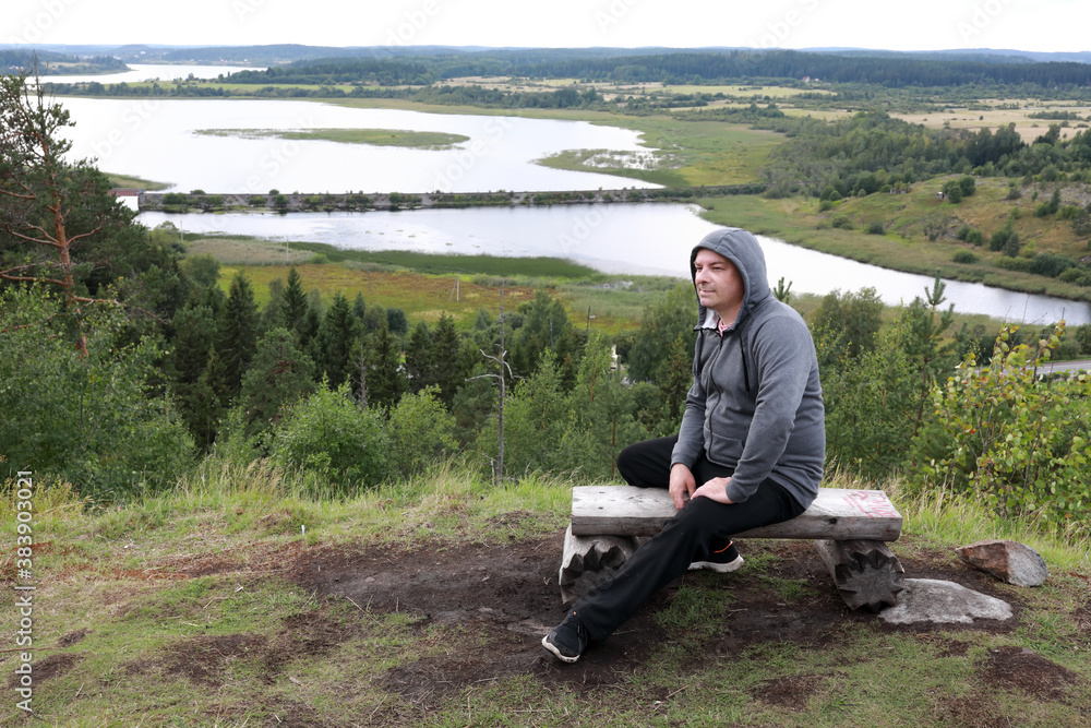 Man relaxing on bench On Mount Paaso in Karelia