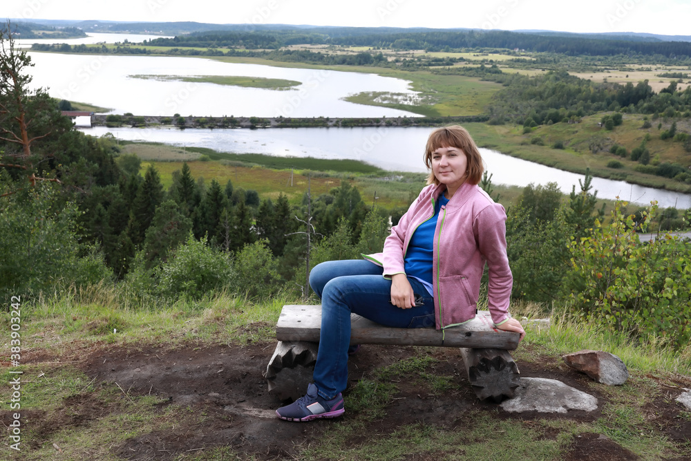 Woman sitting on bench On Mount Paaso in Karelia