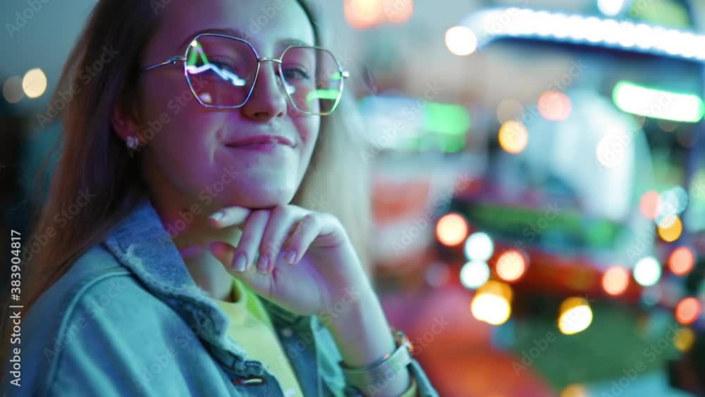 Portrait of young woman at amusement park with bright lights Portrait of young woman at amusement park with bright lights