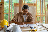 senior Asian man working on wood  work home improvement DIY in workshop recoding streaming online