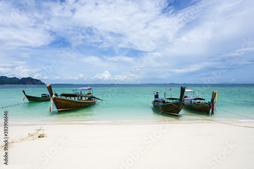 Beautiful views of the sandy beach with long-tailed wooden boats docked on Poda Island, Krabi, Thailand © Yanawut Suntornkij