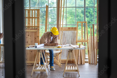 senior Asian man working on wood  work home improvement DIY in workshop recoding streaming online