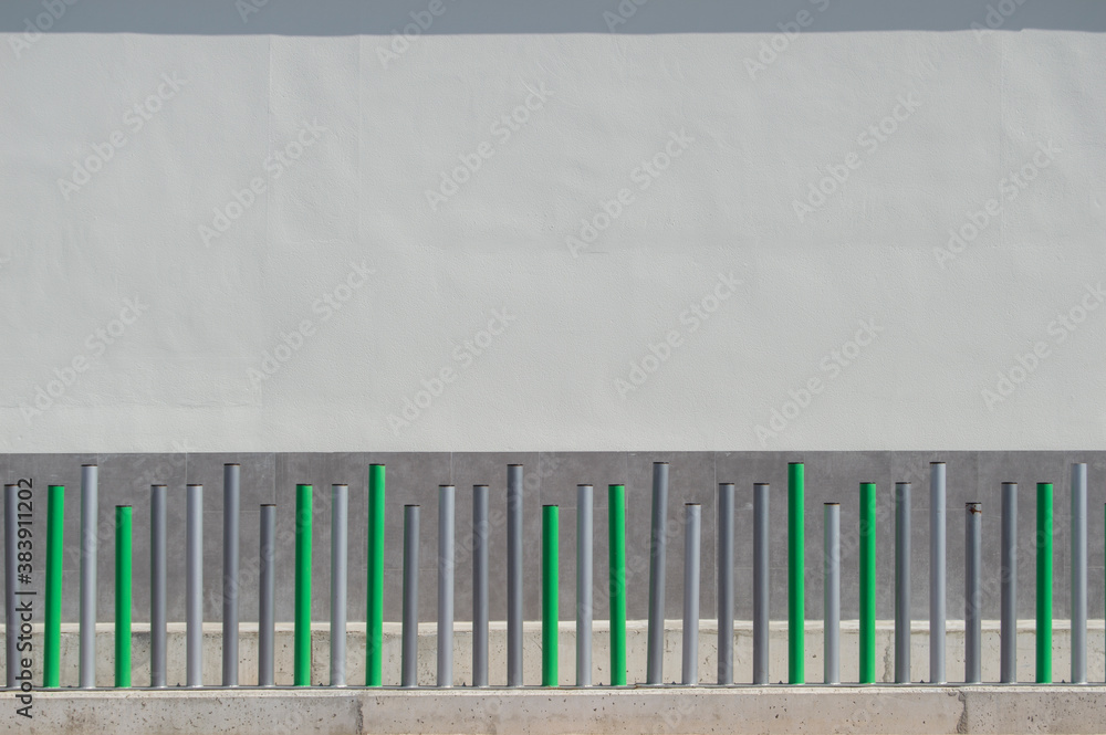 mooth white and gray wall with small bollards of different sizes in green and different shades of gray mooth white and gray wall with small bollards of different sizes in green and different shades of gray
