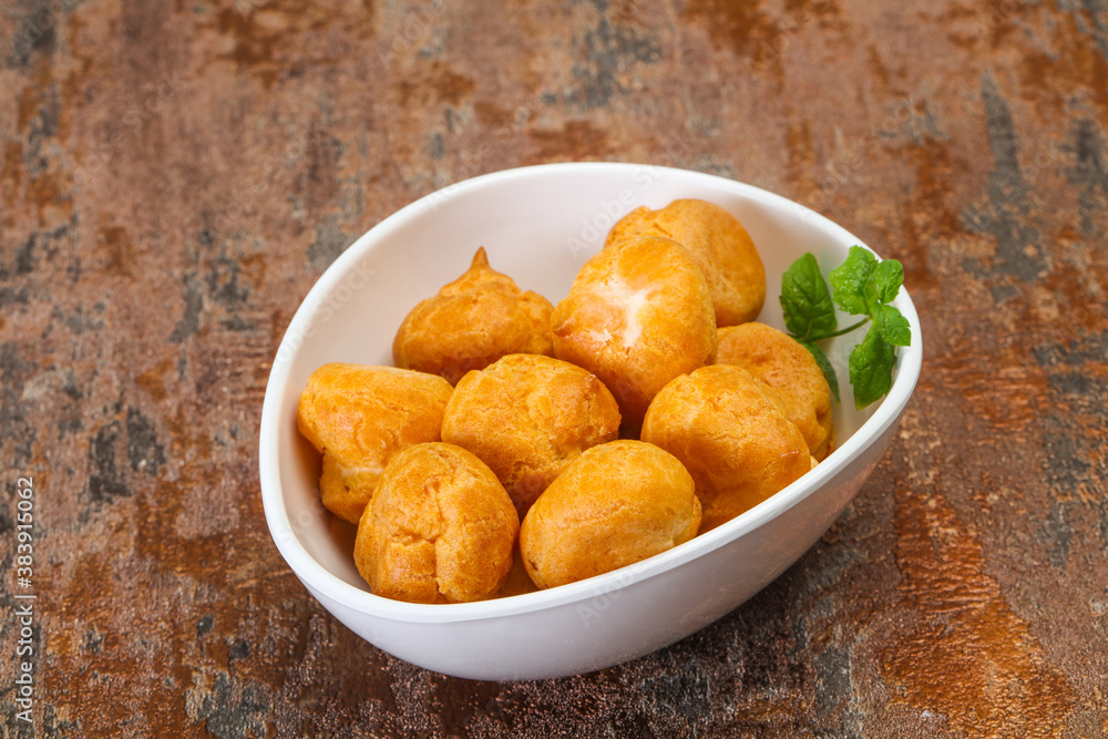 Sweet tasty profiteroles heap in the bowl Sweet tasty profiteroles heap in the bowl